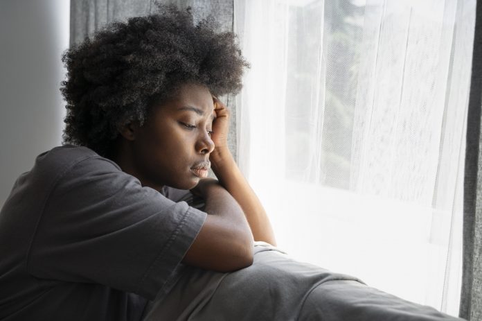mulher-negra-na-janela-relfexiva-com-depressao-melancolica