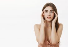 woman having headache during periods feeling frustrated concerned touching temples frowning from discomfort suffering from painful feeling migraine standing concerned 1 1