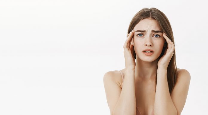 woman having headache during periods feeling frustrated concerned touching temples frowning from discomfort suffering from painful feeling migraine standing concerned 1 1