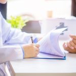 doctor man consulting patient while filling up application form desk hospital 1 scaled