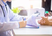 doctor man consulting patient while filling up application form desk hospital 1 scaled