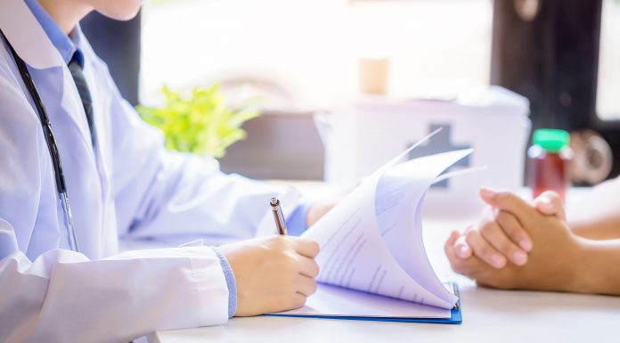 doctor man consulting patient while filling up application form desk hospital 1 scaled