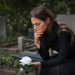 mulher-no-cemiterio-com-flor-branca-luto-por-suicidio