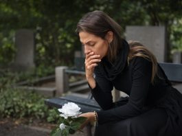 mulher-no-cemiterio-com-flor-branca-luto-por-suicidio